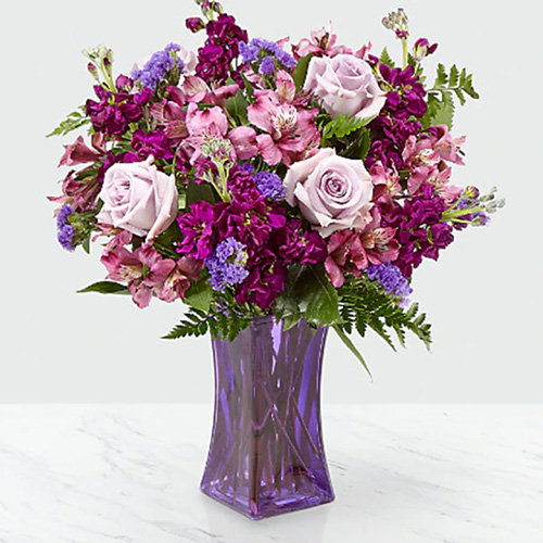 Purple Assorted Flowers in a Vase With Greens